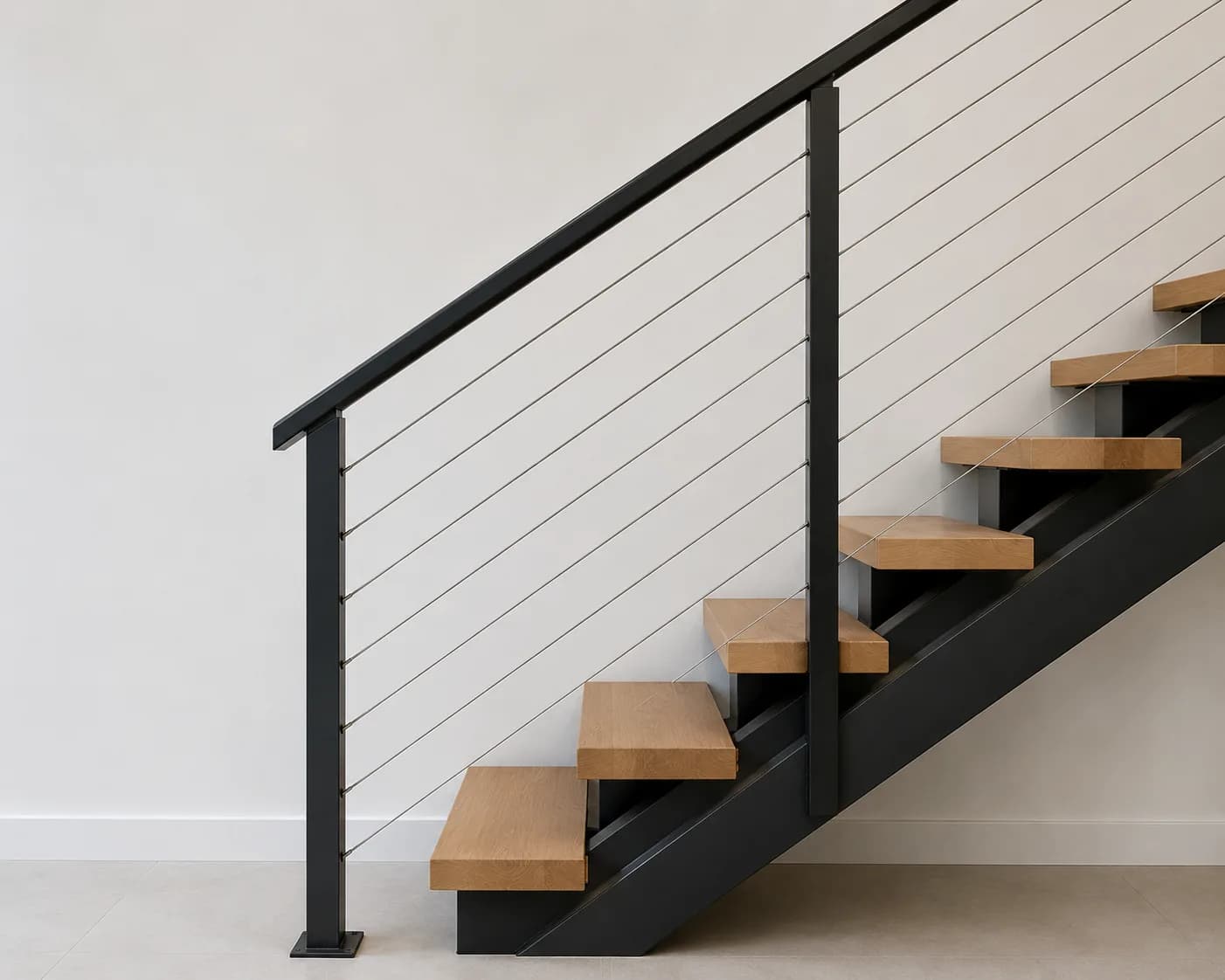 Stainless steel cable handrail system on metal stringer staircase