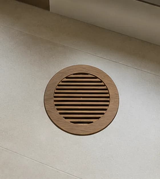 Round-face slotted wooden vent register with circular cut-out in square frame